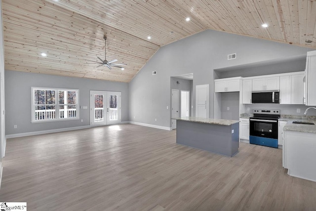 kitchen featuring sink, high vaulted ceiling, white cabinets, a center island, and stainless steel range with electric cooktop