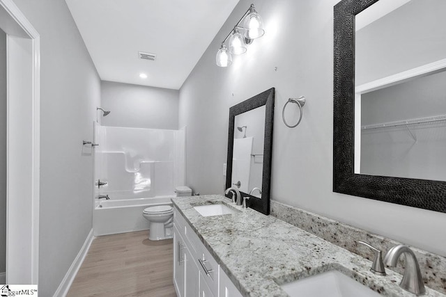 full bathroom featuring hardwood / wood-style floors, vanity, toilet, and bathtub / shower combination