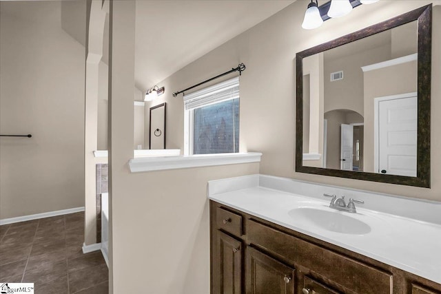 bathroom with vanity and lofted ceiling