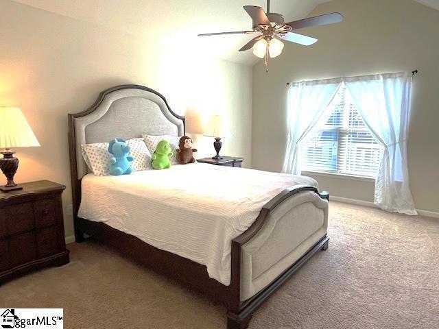 carpeted bedroom with vaulted ceiling and ceiling fan