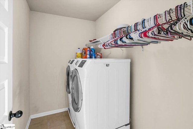 laundry area with light tile patterned floors and washer and clothes dryer