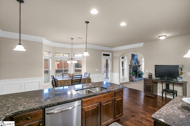 kitchen with stainless steel dishwasher, dark stone countertops, sink, and hanging light fixtures