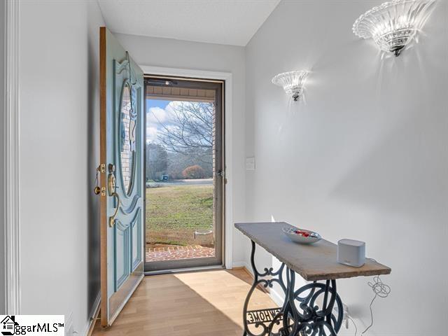 doorway featuring light hardwood / wood-style flooring and a notable chandelier