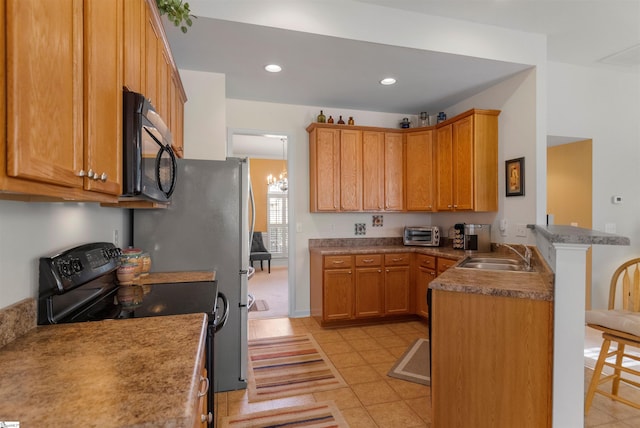 kitchen with black appliances, sink, light tile patterned floors, kitchen peninsula, and a chandelier