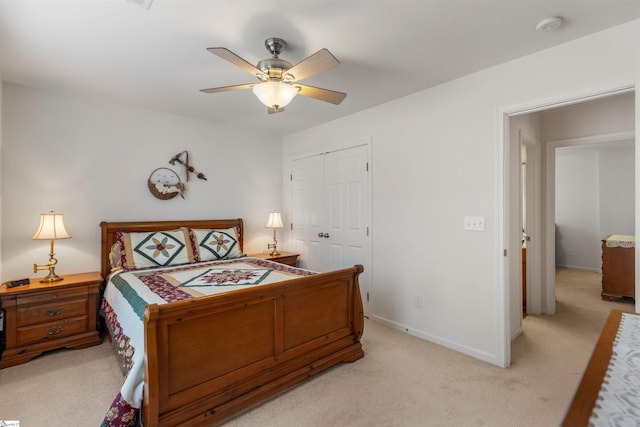 bedroom with a closet, ceiling fan, and light colored carpet