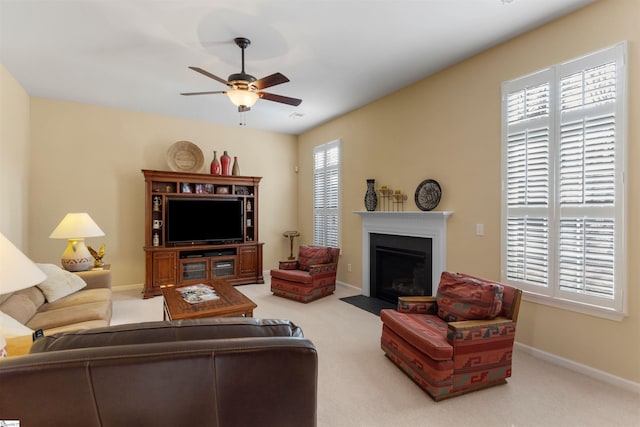 carpeted living room with ceiling fan