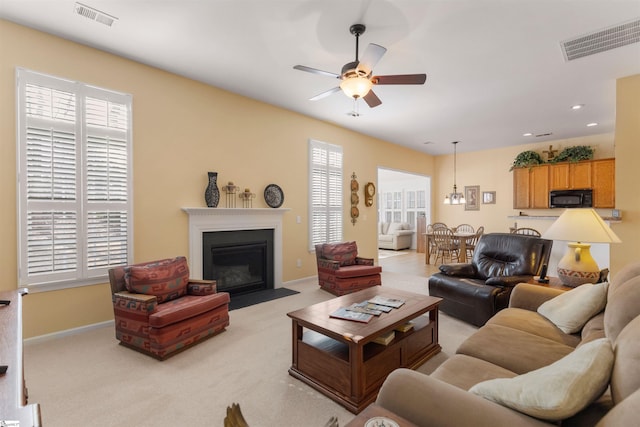 carpeted living room featuring ceiling fan and a healthy amount of sunlight