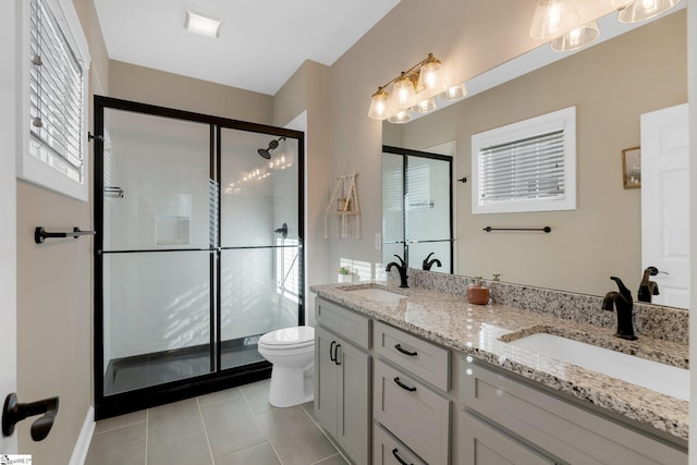 bathroom with tile patterned floors, toilet, vanity, and walk in shower