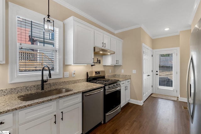 kitchen with light stone countertops, white cabinetry, sink, stainless steel appliances, and pendant lighting