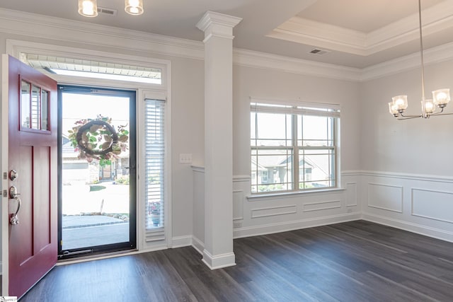 entrance foyer with a raised ceiling, crown molding, dark hardwood / wood-style flooring, and a chandelier