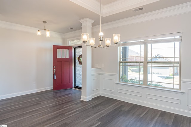 foyer with an inviting chandelier, dark wood-type flooring, and ornamental molding