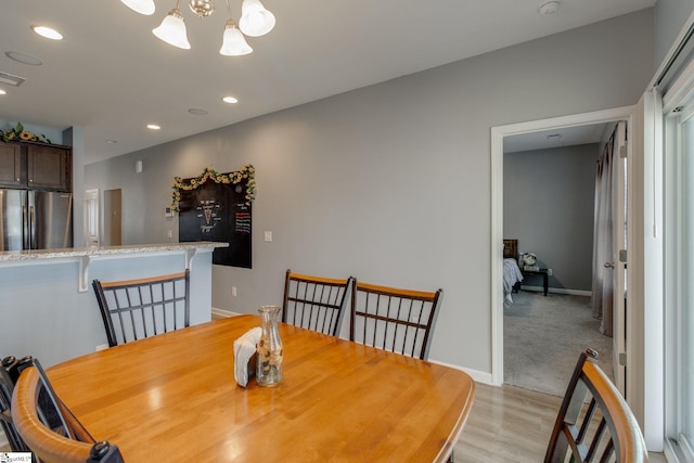 dining area featuring light hardwood / wood-style flooring and an inviting chandelier