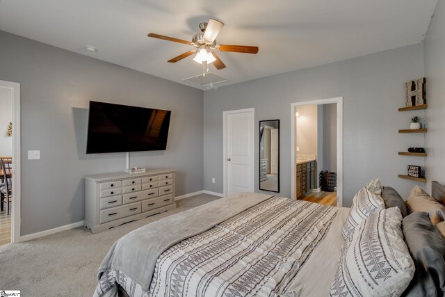 bedroom with ceiling fan, light colored carpet, and ensuite bathroom