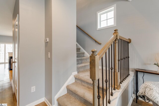 staircase with plenty of natural light and hardwood / wood-style floors