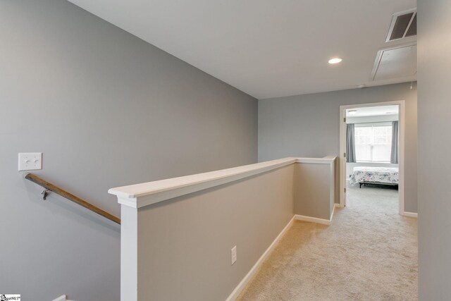 hall with light colored carpet