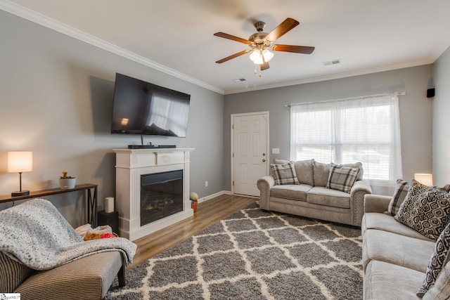 living room with ceiling fan, dark hardwood / wood-style floors, and ornamental molding