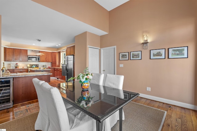 dining area with hardwood / wood-style flooring and beverage cooler