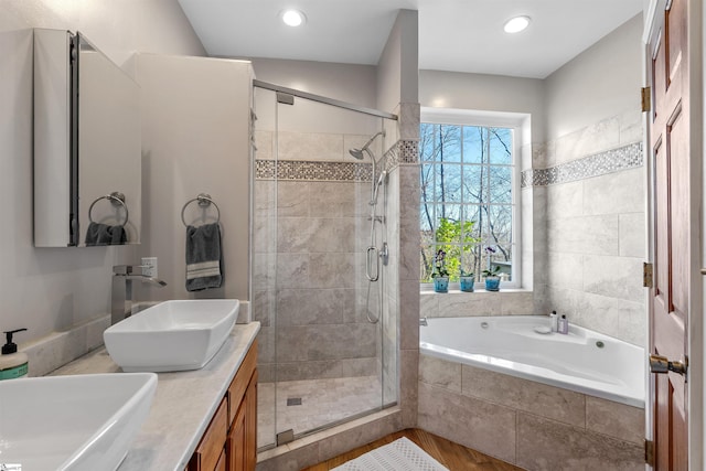 bathroom featuring vanity, wood-type flooring, and plus walk in shower