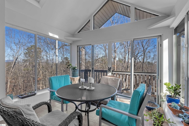 sunroom / solarium featuring lofted ceiling and a healthy amount of sunlight