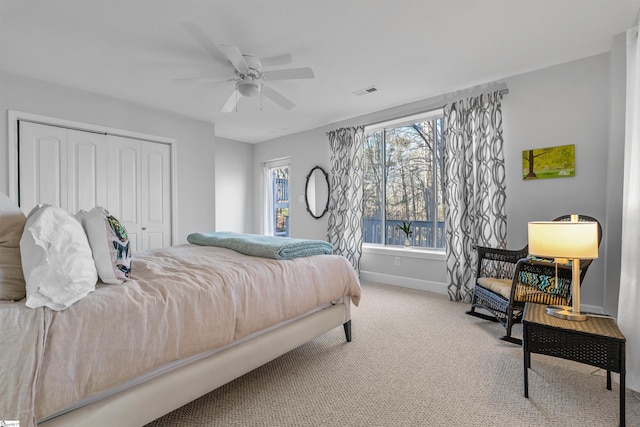 carpeted bedroom featuring ceiling fan and a closet