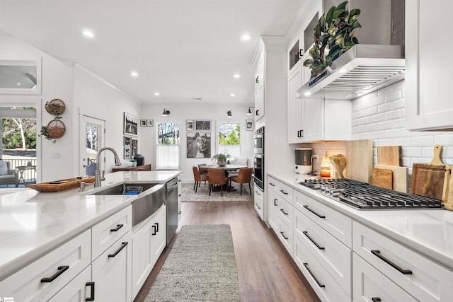 kitchen featuring dark wood-type flooring, backsplash, white cabinets, sink, and stainless steel appliances