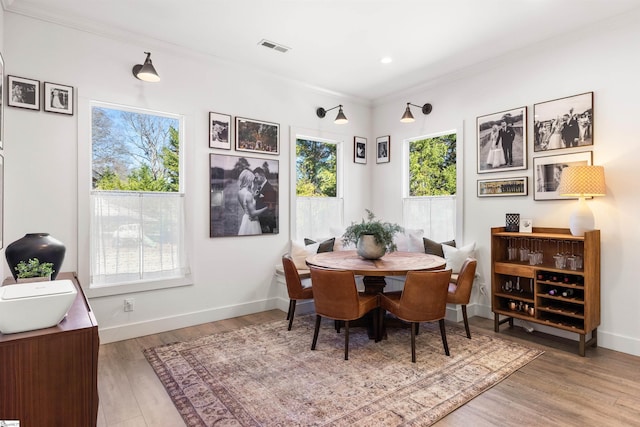 dining room featuring hardwood / wood-style floors and ornamental molding