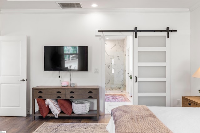 bedroom featuring ensuite bath, crown molding, dark hardwood / wood-style flooring, and a barn door