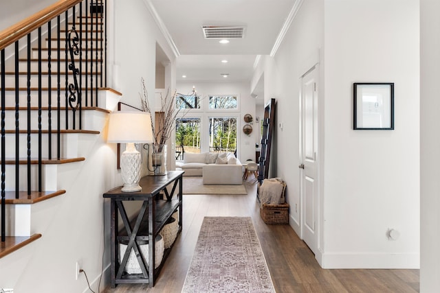 hall with wood-type flooring and crown molding