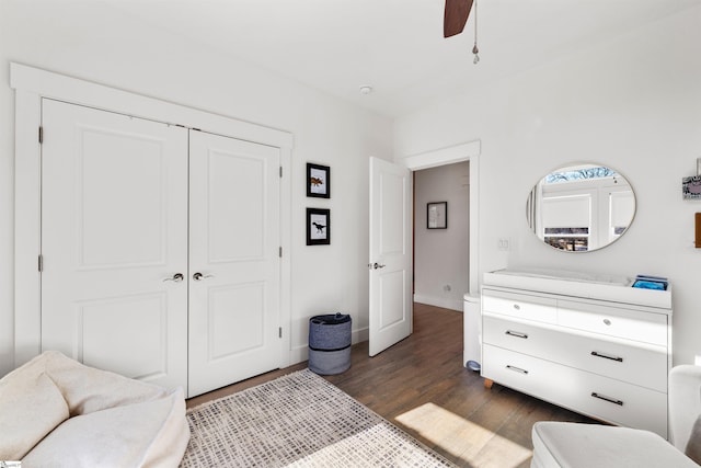 bedroom with dark hardwood / wood-style flooring, ceiling fan, and a closet