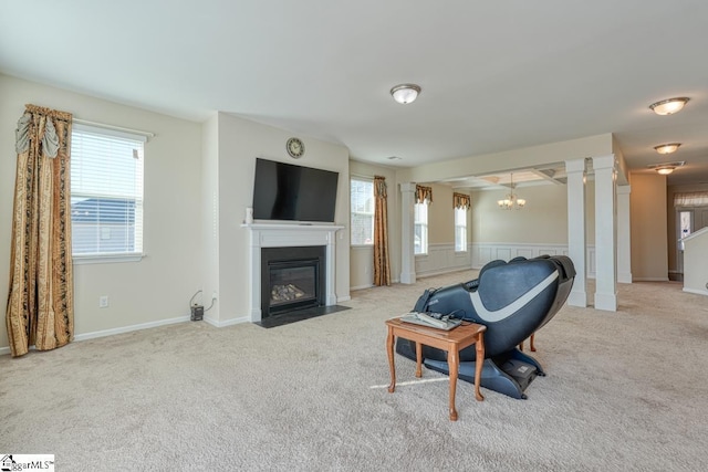 living room featuring light colored carpet, a wealth of natural light, and an inviting chandelier