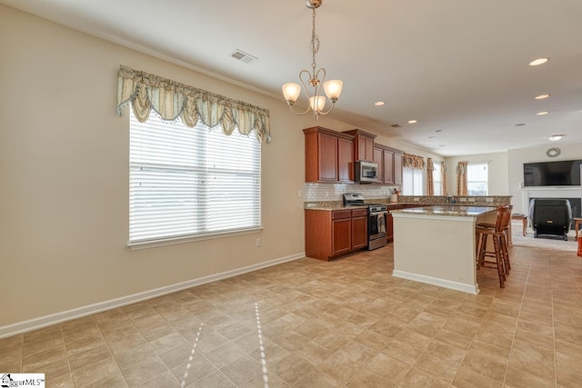 kitchen featuring a kitchen breakfast bar, decorative backsplash, decorative light fixtures, light stone counters, and stainless steel appliances