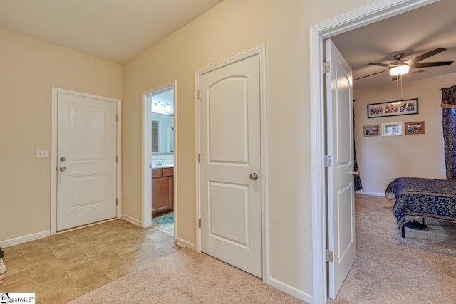 corridor featuring light colored carpet and sink