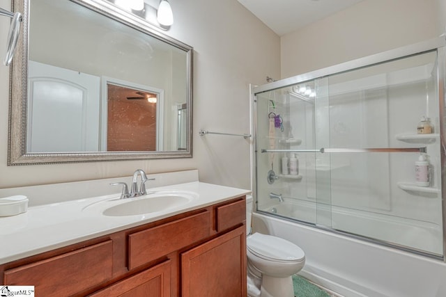 full bathroom featuring vanity, toilet, and bath / shower combo with glass door