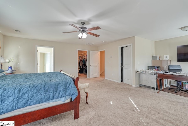 bedroom featuring ceiling fan, a closet, light colored carpet, and a spacious closet