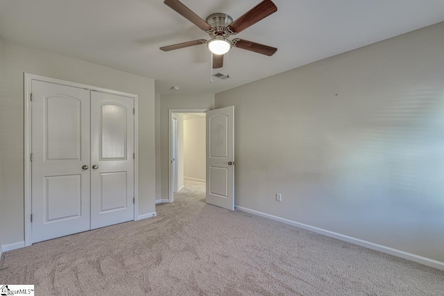 unfurnished bedroom with ceiling fan, a closet, and light carpet