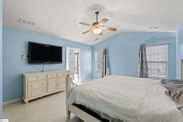 bedroom featuring light wood-type flooring, vaulted ceiling, ceiling fan, and connected bathroom