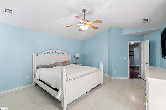 bedroom with ceiling fan, vaulted ceiling, and light wood-type flooring