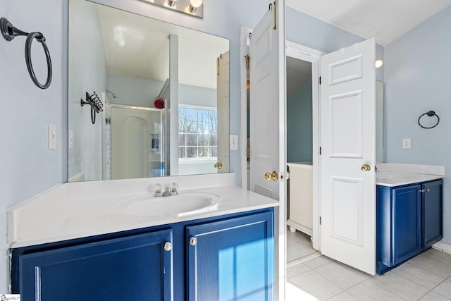 bathroom featuring tile patterned floors, vanity, and a shower with door