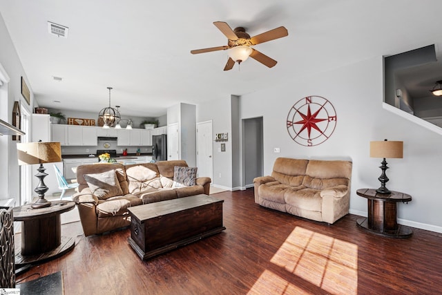 living room featuring ceiling fan with notable chandelier and dark hardwood / wood-style flooring