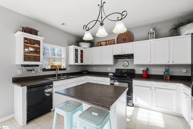 kitchen featuring sink, pendant lighting, a kitchen bar, a kitchen island, and black appliances