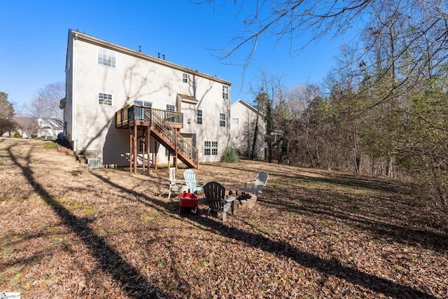 back of property featuring a lawn and a wooden deck