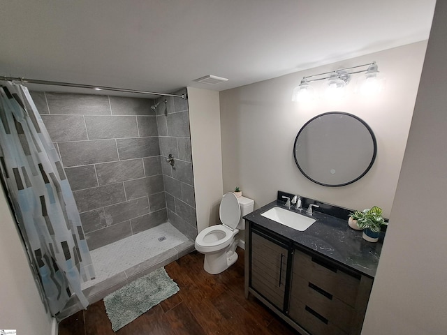 bathroom featuring toilet, a shower with shower curtain, hardwood / wood-style flooring, and vanity