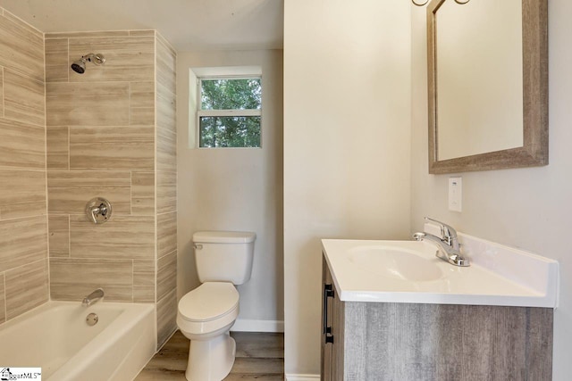 full bathroom featuring hardwood / wood-style floors, vanity, tiled shower / bath combo, and toilet