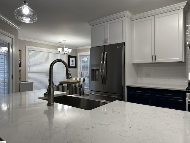 kitchen with stainless steel fridge with ice dispenser, white cabinets, hanging light fixtures, and light stone counters