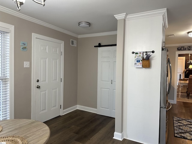 entrance foyer featuring dark hardwood / wood-style flooring, a barn door, an inviting chandelier, and crown molding