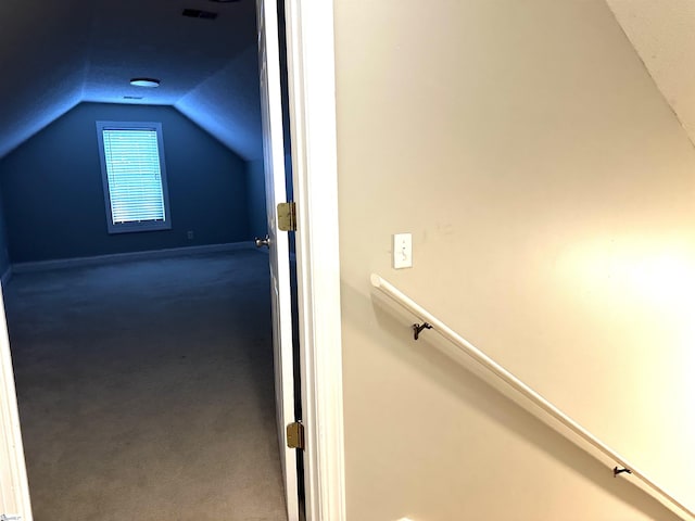 additional living space featuring a textured ceiling and vaulted ceiling