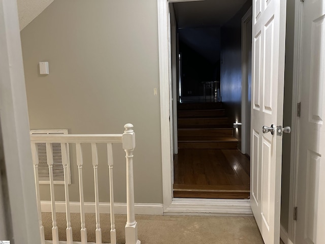 staircase with lofted ceiling, a textured ceiling, and carpet floors