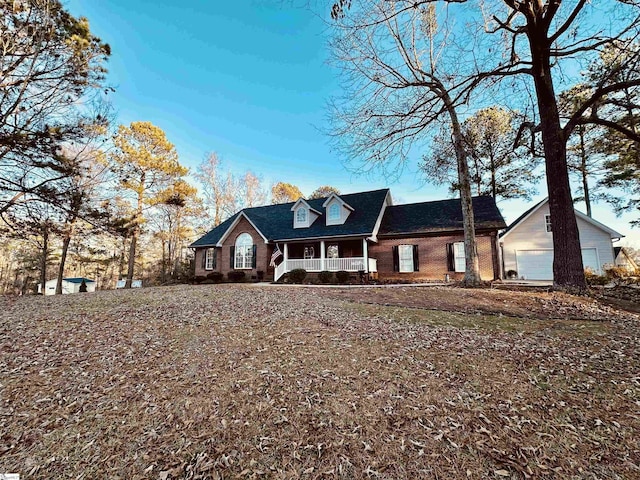 cape cod-style house with covered porch