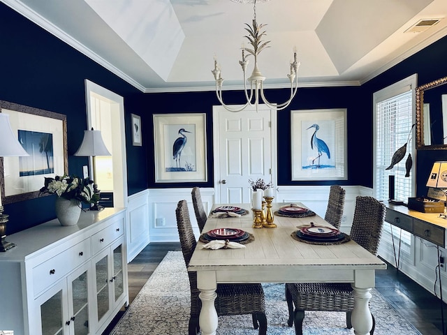 dining space with a raised ceiling, crown molding, and dark hardwood / wood-style floors