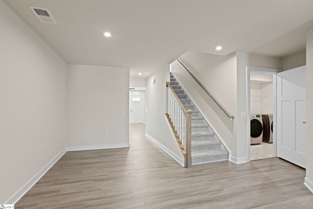 stairs with hardwood / wood-style floors and washer and clothes dryer